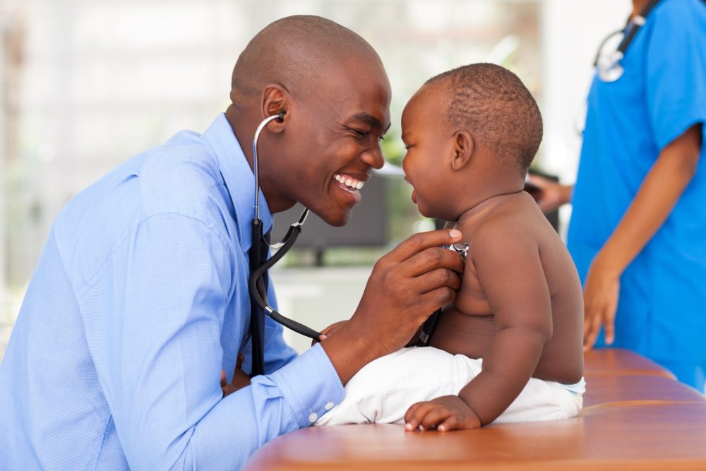 African doctor and baby smiling
