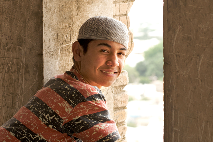 Young Muslim man looking out a window