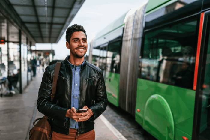 Muslim man standing next to bus