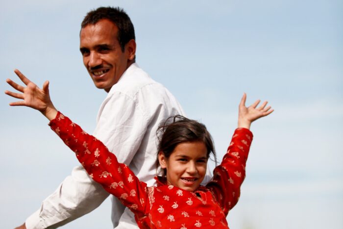 Muslim father and daughter riding a bike