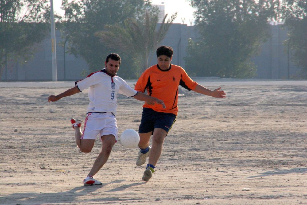 two men playing soccer in the Middle East