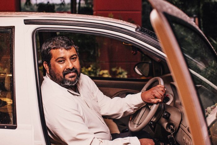 Smiling taxi driver in car