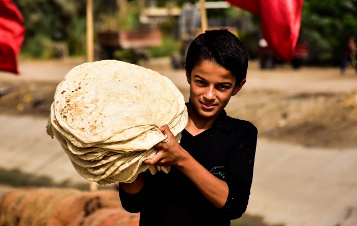 Iraqi boy carrying flatbread