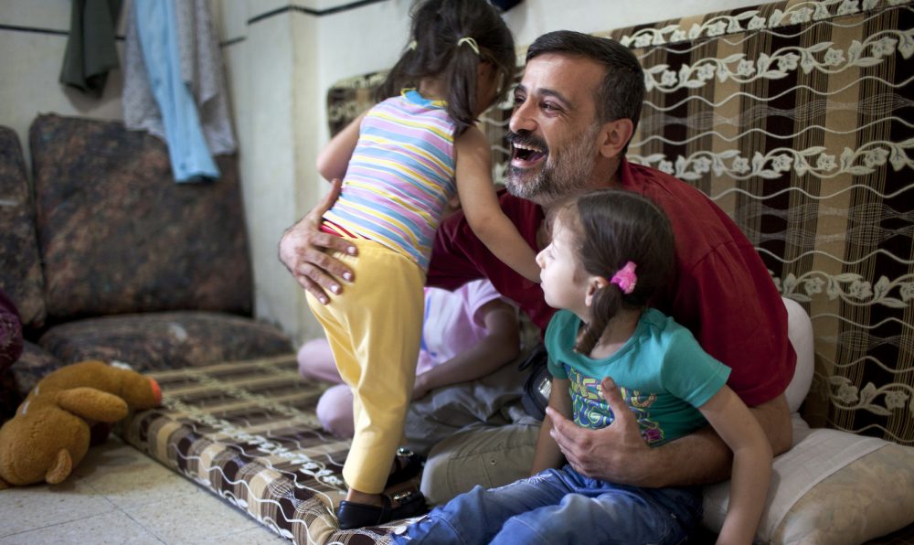 A Syrian man plays with his daughter.